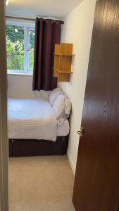 een kleine slaapkamer met een bed en een raam bij Gables in Hither Green