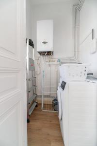 a laundry room with a refrigerator and a sink at Le Louis - Appartement 2 chambres, proche du centre et lac in Vichy