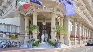 due persone in piedi di fronte a un edificio di Grand Hotel Principe Di Piemonte a Viareggio