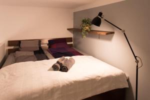 ein Schlafzimmer mit einem Bett mit zwei Handtüchern und einer Lampe in der Unterkunft Budapest Boulvard Green in Budapest