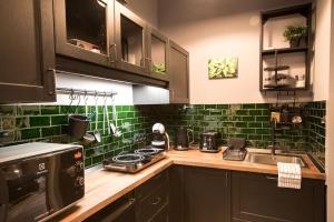 eine Küche mit grünen Wandfliesen in der Unterkunft Budapest Boulvard Green in Budapest