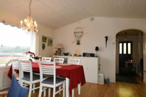 a dining room with a red table and white chairs at Cottage with sea view near Marstrand in Lycke