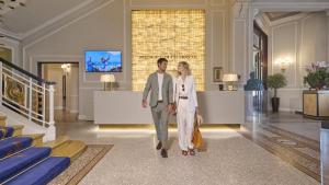 維亞雷焦的住宿－普林西皮迪皮耶蒙特大酒店，男人和女人穿过大厅