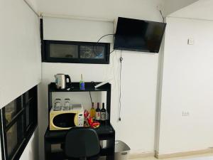 um pequeno quarto com um micro-ondas e uma televisão em bedroom and private bathroom Habitacion y baño privado - en una casa em Córdoba