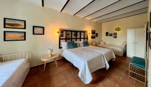 1 dormitorio con 1 cama blanca grande y 1 sofá en Cortijo Isla Virgen, en Villaviciosa de Córdoba