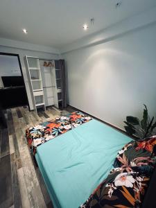 een slaapkamer met een bed in de hoek van een kamer bij Charmant rez de jardin avec acces piscine in Le Tampon