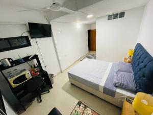 um quarto com uma cama, uma secretária e uma televisão em bedroom and private bathroom Habitacion y baño privado - en una casa em Córdoba