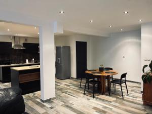 a kitchen and dining room with a table and chairs at Charmant rez de jardin avec acces piscine in Le Tampon