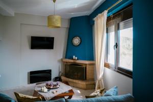 a living room with a table and a fireplace at Ονειρόπετρα in Synikia Mesi Trikalon