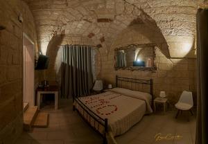 um quarto com uma cama num quarto de pedra em Victoria Luxury Suite em Lizzanello