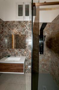 uma casa de banho com um lavatório e um espelho em Victoria Luxury Suite em Lizzanello