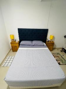 uma cama grande num quarto com duas lâmpadas em bedroom and private bathroom Habitacion y baño privado - en una casa em Córdoba