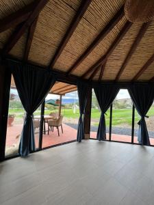 Habitación grande con cortinas negras y mesa. en Cabañas Villa Celeste, en Villa de Leyva