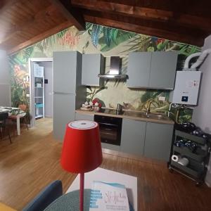 a kitchen with white cabinets and a red lamp at D e c a d e n c e -Wine calling! in Rovato