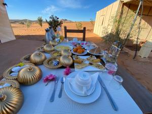 a table with food and pumpkins on it in the desert at Merzouga Heart Luxury Camp in Merzouga
