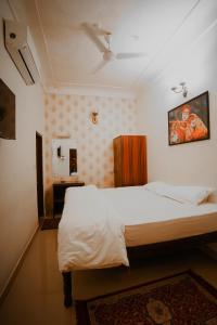 - une chambre avec un grand lit blanc dans l'établissement KARNI VILAS, à Jaipur