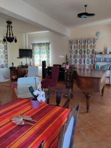 a living room with a table and a piano at Villa Caretta - direkt an einem einsamen Strand im Süden des Peloponnes 