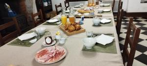 una mesa larga con comida y pan. en La Rossignolerie - Gîte des châteaux, en Chouzy-sur-Cisse
