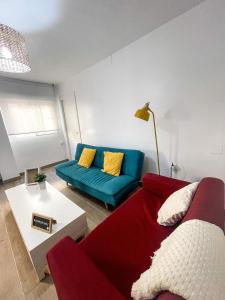 グラナダにあるH&H Suite El Mirloのリビングルーム(赤いソファ、黄色い枕付)