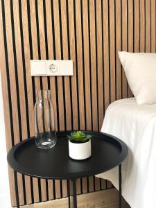a black table with a vase on it next to a bed at H&H Suite El Mirlo in Granada