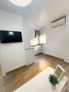 an empty living room with white walls and a table at H&H Suite El Mirlo in Granada