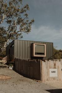 a building with a tv on top of a fence at VIBE LUXURY CABINS in Arnuero