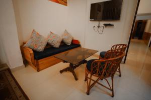 - un salon avec un canapé, une table et des chaises dans l'établissement KARNI VILAS, à Jaipur