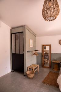 Pokój z drzwiami, stołkiem i lustrem w obiekcie Bessire Chambres & table d'hôtes 