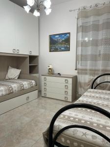 Un dormitorio con dos camas individuales y una cómoda. en Dimora Carmela, en Torre Santa Sabina 35 fotos más