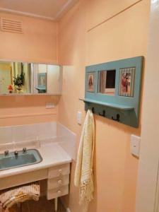 uma casa de banho com um lavatório e um espelho em Gidget's Place em Surf Beach