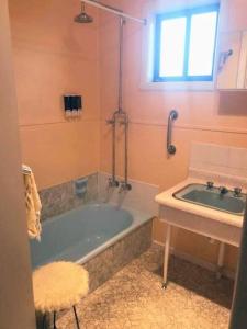 uma casa de banho com uma banheira e um lavatório em Gidget's Place em Surf Beach
