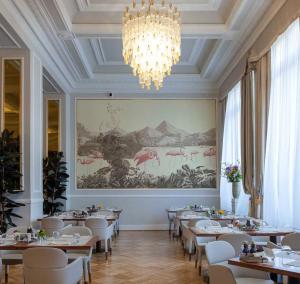 a dining room with tables and chairs and a chandelier at Grand Hotel Principe Di Piemonte in Viareggio