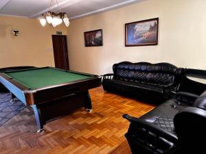 a living room with a pool table and leather couches at Pokoje Gościnne Impresja Kadzidło in Kadzidło