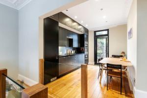 a kitchen with a large black refrigerator and a table at Beautiful two-bed abode Near King Cross in London