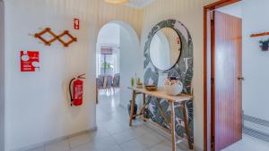 a hallway with a table and a mirror at Casa Brasil 2 BDR With Balcony by LovelyStay in Portimão