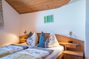 - une chambre avec 2 lits et une tête de lit en bois dans l'établissement Gfinkerhof Mendel, à Vols am Schlern