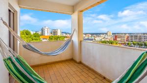 波爾蒂芒的住宿－Casa Brasil 2 BDR With Balcony by LovelyStay，设有带吊床的市景阳台。