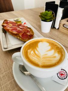 una taza de café y una rebanada de pizza en una mesa en Apartamentos rurales, La Casa de Baltasar, en Fondón