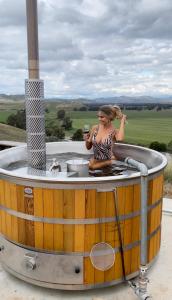 a woman in a hot tub with a glass of wine at Kimo Estate in Gundagai