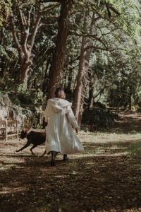 a woman in a dress walking a dog in a park at VIBE LUXURY CABINS in Arnuero