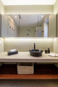 ein Badezimmer mit Waschbecken und großem Spiegel in der Unterkunft AJ VILLA KEA in Otziás