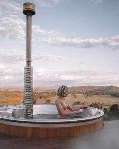 岡德蓋的住宿－奇摩農家樂，坐在热水浴缸中的人,享有美景