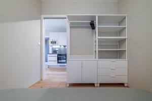 a white closet with shelves and a kitchen at Trio Harrachov in Harrachov