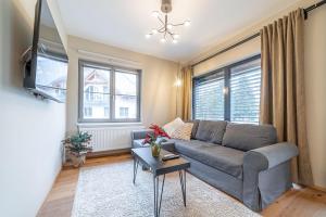 a living room with a couch and a tv at Trio Harrachov in Harrachov