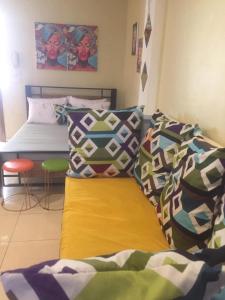 a bedroom with a bed with colorful sheets and pillows at Arcobaleno in Manila