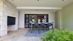 ein Esszimmer mit einem Tisch und einigen Stühlen in der Unterkunft Pearl Valley Golf Lodge - loadshedding free in Simondium