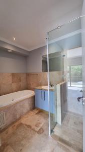 ein Badezimmer mit Dusche und Badewanne in der Unterkunft Pearl Valley Golf Lodge - loadshedding free in Simondium