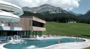 a resort with a swimming pool with people in it at Alpine Cocoon in Churwalden