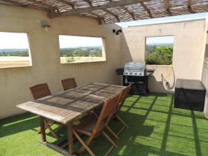 - une table et des chaises sur une terrasse avec barbecue dans l'établissement Le Gîte de la Bade, à Villegailhenc