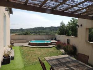 a backyard with a swimming pool with a table and chairs at Le Gîte de la Bade in Villegailhenc